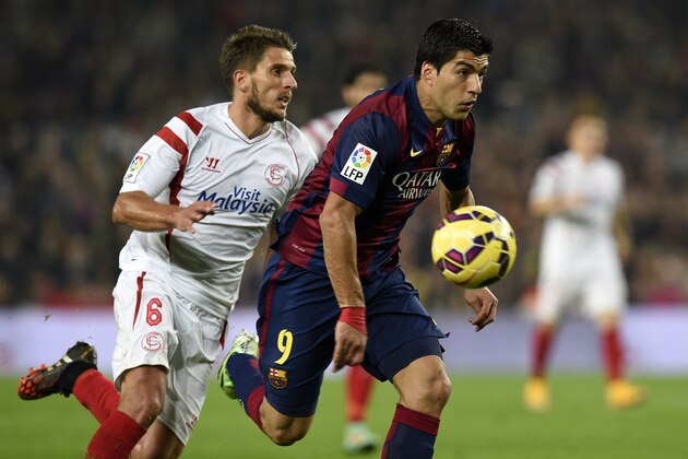 Barcelona's Uruguayan forward Luis Suarez (R) vies with Sevilla's Portuguese midfielder Daniel Carrico (L) during the Spanish league football match FC Barcelona vs Sevilla FC at the Camp Nou stadium in Barcelona on November 22, 2014.   AFP PHOTO / LLUIS GENE        (Photo credit should read LLUIS GENE/AFP/Getty Images)