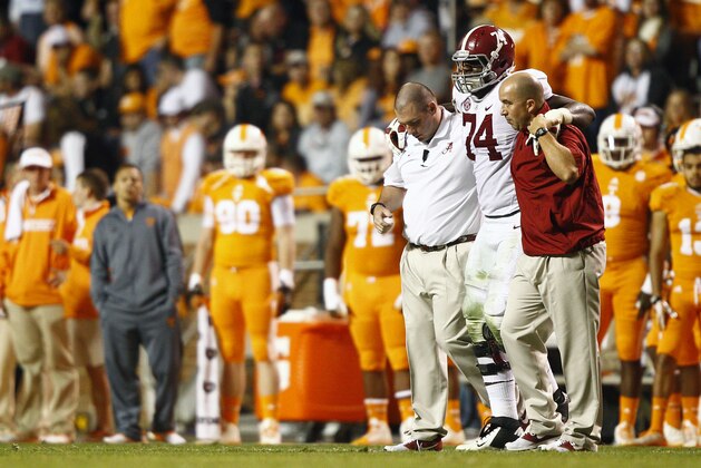 Alabama offensive lineman Cam Robinson (74) is helped from the field after being injured in the third quarter of an NCAA college football game Saturday, Oct. 25, 2014 in Knoxville, Tenn. (AP Photo/Wade Payne)