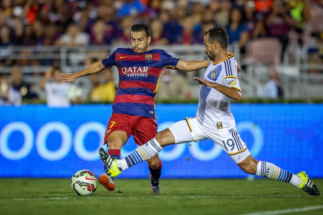 IMAGE DISTRIBUTED FOR INTERNATIONAL CHAMPIONS CUP - FC Barcelona's Pedro Rodriguez tries to keep ahead of LA Galaxy's AJ De La Garza during Tuesday's soccer match at the Rose Bowl in Pasadena, Calif., Tuesday, July 21, 2015. (Doug Benc/AP Images for International Champions Cup)