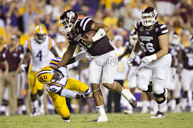 BATON ROUGE, LA - SEPTEMBER 20: Dak Prescott #15 of the Mississippi State Bulldogs stiff arms Jalen Mills #28 of the LSU Tigers at Tiger Stadium on September 20, 2014 in Baton Rouge, Louisiana.  The Bulldogs defeated the Tigers 34-29.  (Photo by Wesley Hitt/Getty Images)