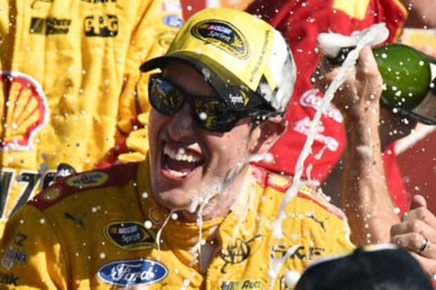 Joey Logano celebrates in the victory lane after winning a NASCAR Sprint Cup series auto race at Watkins Glen International, Sunday, Aug. 9, 2015, in Watkins Glen. N.Y. (AP Photo/Derik Hamilton)