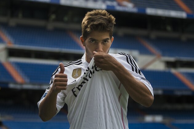 Brazil international soccer player Lucas Silva kisses his t-shirt as he poses during his official presentation at the Santiago Bernabeu stadium in Madrid, Spain, Monday, Jan. 26, 2015, after signing for Real Madrid. (AP Photo/Andres Kudacki)