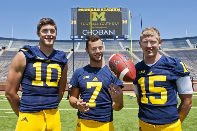 Michigan quarterbacks Zach Gentry (10), Shane Morris (7), and Jake Rudock (15) pose for a photo  in Michigan Stadium during the NCAA college football team's annual media day in Ann Arbor, Mich., Thursday, Aug. 6, 2015. (AP Photo/Tony Ding)