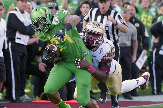 Oregon running back Thomas Tyner, left, runs past Florida State's Matthew Thomas during the first half of the Rose Bowl NCAA college football playoff semifinal, Thursday, Jan. 1, 2015, in Pasadena, Calif. (AP Photo/Mark J. Terrill)