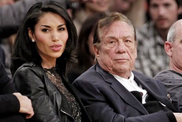 FILE - In this Dec. 19, 2011, file photo, Los Angeles Clippers owner Donald Sterling, right, sits with V. Stiviano as they watch the Clippers play the Los Angeles Lakers during an NBA preseason basketball game in Los Angeles. A Los Angeles judge ruled Tuiesday April 14, 2015 that the wife of the former Clippers owner is owed $2.6 million by V. Stiviano, a woman Donald Sterling showered with gifts. (AP Photo/Danny Moloshok, File)