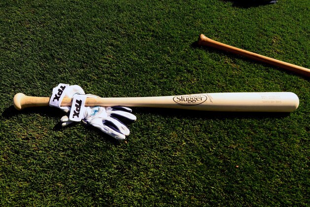 Feb 28, 2014; Port Charlotte, FL, USA; A baseball bat and batting gloves lie on the grass before the Tampa Bay Rays and Baltimore Orioles play in a spring training exhibition game at Charlotte Sports Park. Mandatory Credit: David Manning-USA TODAY Sports