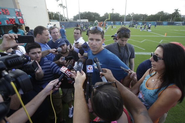 Miami Dolphins offensive coordinator Bill Lazor, center, talks to the media at NFL football training camp, Tuesday, Aug. 4, 2015, in Davie, Fla. (AP Photo/Wilfredo Lee)