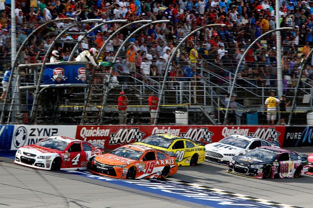 BROOKLYN, MI - JUNE 14:  Carl Edwards, driver of the #19 ARRIS Toyota, and Kevin Harvick, driver of the #4 Budweiser/Jimmy John's Chevrolet, lead the field to a restart during the NASCAR Sprint Cup Series Quicken Loans 400 at Michigan International Speedway on June 14, 2015 in Brooklyn, Michigan.  (Photo by Jerry Markland/Getty Images)