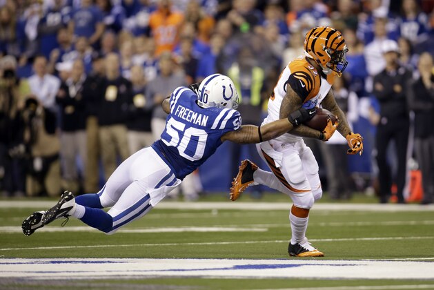 Cincinnati Bengals running back Jeremy Hill, right, runs with the ball as Indianapolis Colts linebacker Jerrell Freeman defends during the first half of an NFL wildcard playoff football game Sunday, Jan. 4, 2015, in Indianapolis. (AP Photo/AJ Mast)