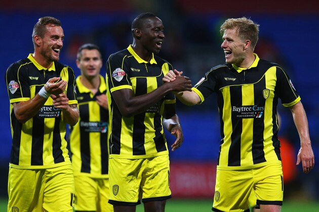 BOLTON, ENGLAND - AUGUST 11:  Aurelien Joachim, Lucas Akins and Damien McCrory of Burton Albion celebrate victory after the Capital One Cup first round match between Bolton Wanderers and Burton Albion at Macron Stadium on August 11, 2015 in Bolton, England.  (Photo by Alex Livesey/Getty Images)