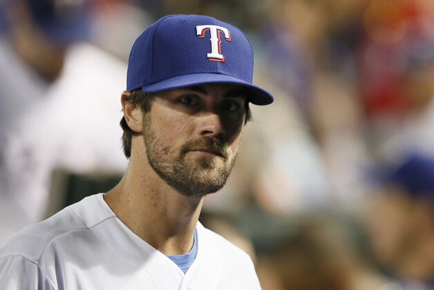 Newly acquired Texas Rangers pitcher Cole Hamels walks through the dugout in the seventh inning of a baseball game against the San Francisco Giants Friday, July 31, 2015, in Arlington, Texas. (AP Photo/Tony Gutierrez)