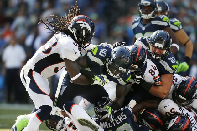 Seattle Seahawks fullback Derrick Coleman (40) piles up with Denver Broncos strong safety Quinton Carter, left, and tight end Jacob Tamme (84) in the second half of an NFL football game, Sunday, Sept. 21, 2014, in Seattle. (AP Photo/John Froschauer)