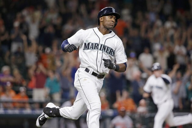 Seattle Mariners' Austin Jackson heads to first after hitting in the winning run as Logan Morrison heads home to score against the Baltimore Orioles in the 10th inning of a baseball game Tuesday, Aug. 11, 2015, in Seattle. (AP Photo/Elaine Thompson)