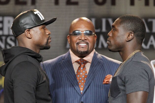 Floyd Mayweather Jr., left, and Andre Berto face each other at a news conference in Los Angeles on Thursday, Aug. 6, 2015. Mayweather Promotions CEO Leonard Ellerbe is in the middle. Mayweather says Berto is a worthy opponent for the final fight of his perfect career. Three months after Mayweather dominated Manny Pacquiao in the most lucrative fight in boxing history, he began the difficult business of promoting his pay-per-view bout with Berto with a news conference in downtown Los Angeles. (AP Photo/Nick Ut)