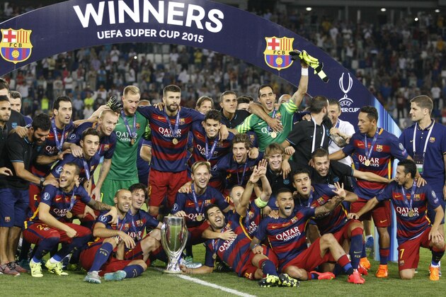 Barcelona players celebrate with the trophy after winning the UEFA Super Cup soccer match between FC Barcelona and Sevilla FC at the Boris Paichadze Dinamo Arena stadium, in Tbilisi, Georgia, Tuesday, Aug. 11, 2015. (AP Photo/Shakh Aivazov)