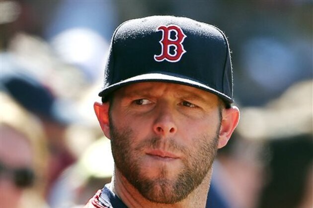 Injured Boston Red Sox second baseman Dustin Pedroia looks on from the dugout during a 4-3 loss to the Tampa Bay Rays in a baseball game at Fenway Park in Boston, Sunday, Aug. 2, 2015. (AP Photo/Winslow Townson)