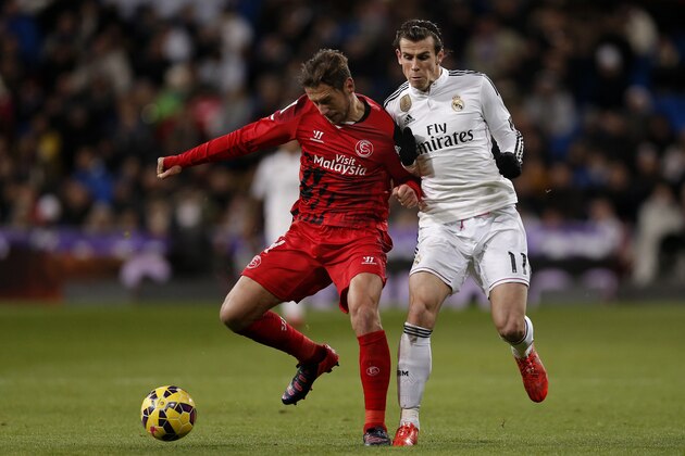 Real Madrid's Gareth Bale from Britain, right, duels for the ball with Sevilla's Grzegorz Krychowiak during a Spanish La Liga soccer match between Real Madrid and Sevilla at the Santiago Bernabeu stadium in Madrid, Spain, Wednesday, Feb. 4, 2015. (AP Photo/Daniel Ochoa de Olza)