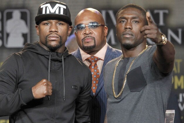 Boxers, Floyd Mayweather, Jr., left, and Andre Berto, right, pose for a photo at a news conference in Los Angeles on Thursday, Aug. 6, 2015. Mayweather Promotions, CEO Leonard Ellerbe, middle. Mayweather says Berto is a worthy opponent for the final fight of his perfect career. Three months after Mayweather dominated Manny Pacquiao in the most lucrative fight in boxing history, he began the difficult business of promoting his pay-per-view bout with Berto with a news conference in downtown Los Angeles. (AP Photo/Nick Ut)