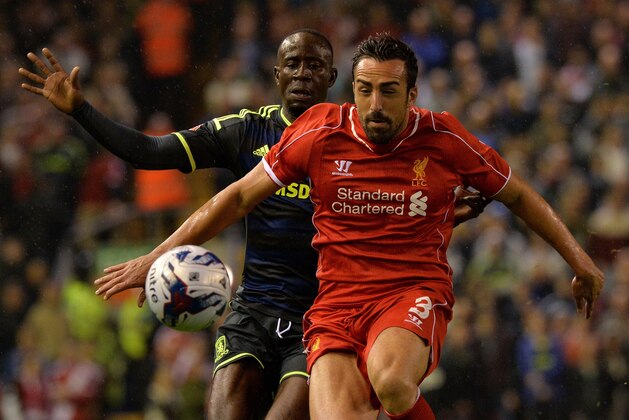 Liverpool's Spanish defender Jose Enrique (R) vies with Middlesbrough's Ghanaian midfielder Albert Adomah (L) during the English League Cup third round football match between Liverpool and Middlesbrough at Anfield in Liverpool, north west England on September 23, 2014. AFP PHOTO / PAUL ELLIS

RESTRICTED TO EDITORIAL USE. No use with unauthorized audio, video, data, fixture lists, club/league logos or 'live' services. Online in-match use limited to 45 images, no video emulation. No use in betting, games or single club/league/player publications.        (Photo credit should read PAUL ELLIS/AFP/Getty Images)