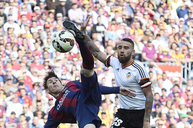 FC Barcelona's Lionel Messi, left, duels for the ball against Valencia's Nicolas Otamendi during a Spanish La Liga soccer match at the Camp Nou stadium in Barcelona, Spain, Saturday, April 18, 2015. (AP Photo/Manu Fernandez)
