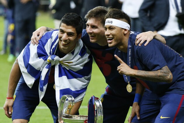 Barcelona's Lionel Messi, centre, Neymar and Luis Suarez, left, celebrate with the trophy after after the Champions League final soccer match between Juventus Turin and FC Barcelona at the Olympic stadium in Berlin Saturday, June 6, 2015. Barcelona won the match 3-1.   (AP Photo/Luca Bruno)