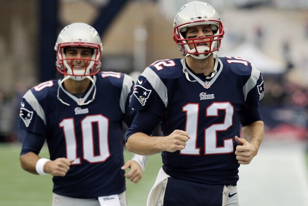 New England Patriots quarterbacks Jimmy Garoppolo (10) and Tom Brady (12) run onto the field for warms-up's before an NFL football game against the Buffalo Bills Sunday, Dec. 28, 2014, in Foxborough, Mass. (AP Photo/Charles Krupa)