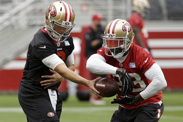 San Francisco 49ers quarterback Blaine Gabbert, left, hands off to running back Reggie Bush during an NFL football mini-camp in Santa Clara, Calif., Wednesday, June 10, 2015. (AP Photo/Jeff Chiu)