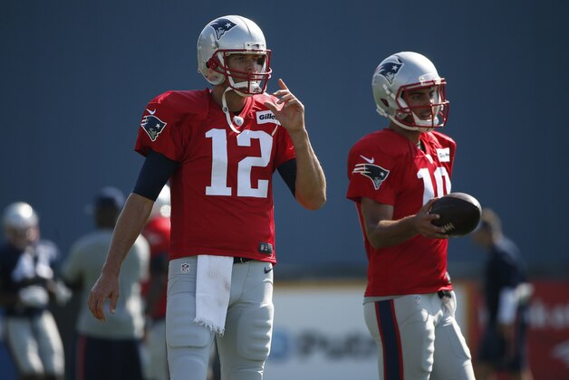 New England Patriots quarterbacks Tom Brady (12) and Jimmy Garoppolo (10) stand on the field during an NFL football training camp in Foxborough, Mass., Saturday, Aug. 1, 2015. (AP Photo/Michael Dwyer)