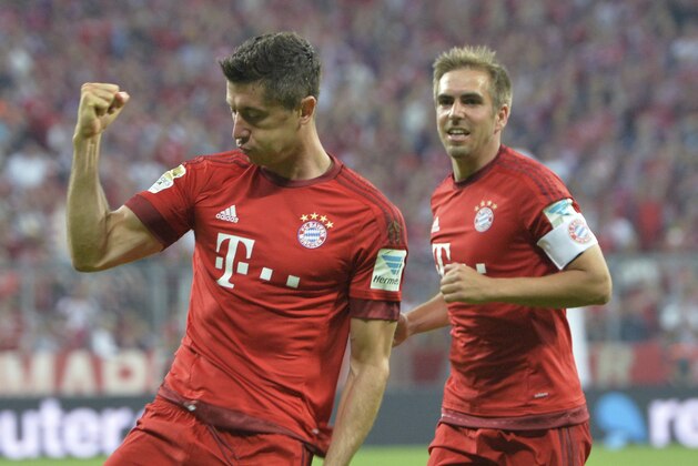 Bayern's Philipp Lahm, right, looks on as Robert Lewandowski celebrates after scoring his side's second goal during the German Bundesliga soccer match between FC Bayern Munich and Hamburger SV in Munich, southern Germany, Friday, Aug. 14, 2015. (AP Photo/Kerstin Joensson)