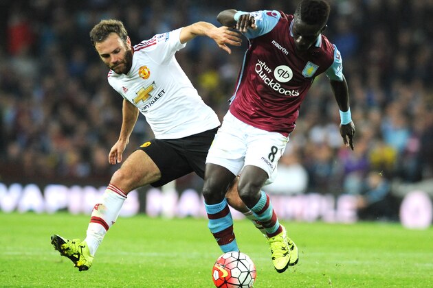 Aston Villa’s Idrissa Gueye, right, holds back Manchester United’s Juan Mata during the English Premier League soccer match between Aston Villa and Manchester United at Villa Park, Birmingham, England, Friday, Aug. 14, 2015. (AP Photo/Rui Vieira)