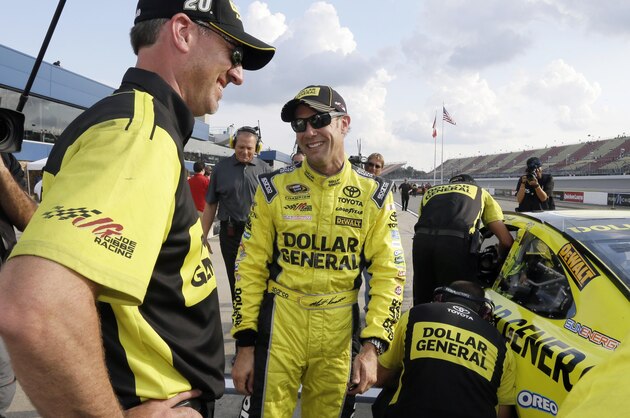 Matt Kenseth talks to a crew member after qualifying Friday, Aug. 14, 2015, for the pole position for the NASCAR Sprint Cup series auto race at Michigan International Speedway, in Brooklyn, Mich. (AP Photo/Carlos Osorio)