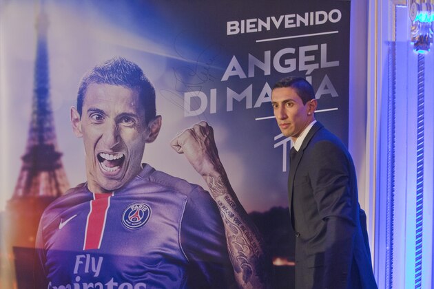 New Argentinean winger Angel Di Maria, poses in front of his poster during his official presentation in Paris, France. Thursday, Aug. 6, 2015.  Angel Di Maria signed a four-year deal with Paris Saint-Germain on Thursday to complete his transfer from Manchester United. (AP Photo/Jacques Brinon)