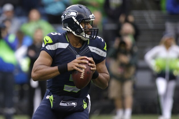 Seattle Seahawks quarterback Russell Wilson drops back during the first half of a preseason NFL football game against the Denver Broncos, Friday, Aug. 14, 2015, in Seattle. (AP Photo/Elaine Thompson)