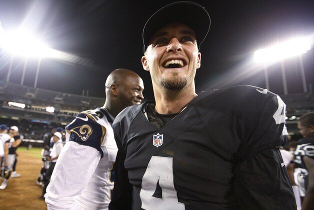 Oakland Raiders quarterback Derek Carr (4) smiles after an NFL preseason football game against the St. Louis Rams in Oakland, Calif., Friday, Aug. 14, 2015. (AP Photo/Tony Avelar)