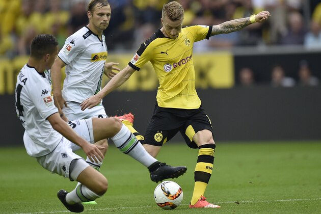 Moenchengladbach's Granit Xhaka, left, tries to stop Dortmund's Marco Reus, right, during the German Bundesliga soccer match between Borussia Dortmund and Borussia Moenchengladbach in Dortmund, Germany, Saturday, Aug. 15, 2015. (AP Photo/Martin Meissner)