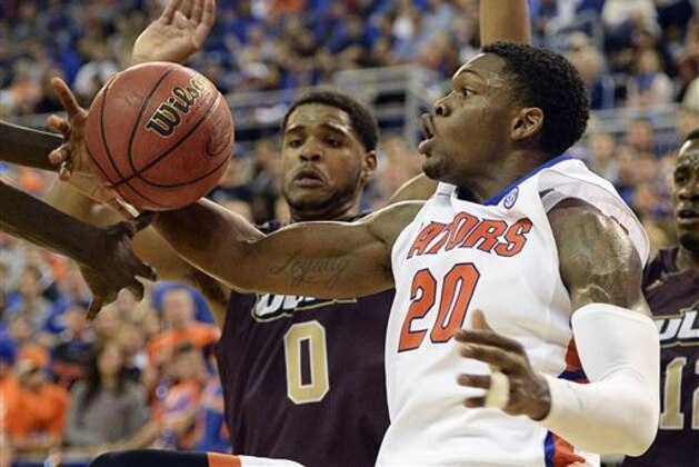 Florida guard Michael Frazier II (20) grabs a rebound with Louisiana-Monroe center Marvin Williams (0) trying to get in the action during the second half of an NCAA college basketball game in Gainesville, Fla., Friday, Nov. 21, 2014. Florida defeated Louisiana-Monroe 61-56 in overtime. (AP Photo/Phil Sandlin)