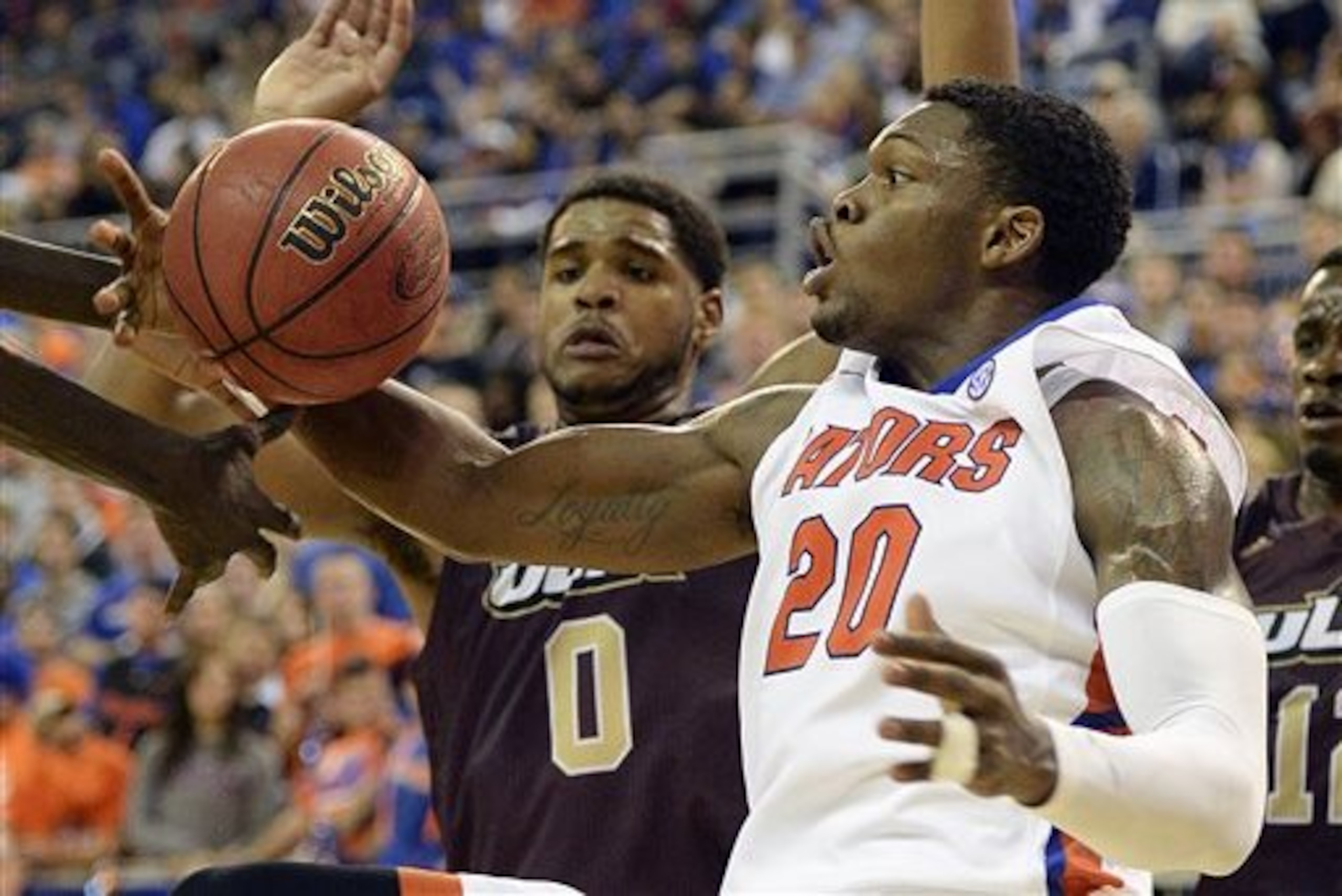 Florida guard Michael Frazier II (20) grabs a rebound with Louisiana-Monroe center Marvin Williams (0) trying to get in the action during the second half of an NCAA college basketball game in Gainesville, Fla., Friday, Nov. 21, 2014. Florida defeated Louisiana-Monroe 61-56 in overtime. (AP Photo/Phil Sandlin)