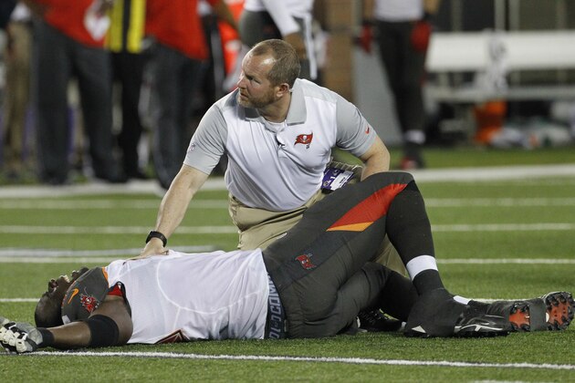 A trainer attends to Tampa Bay Buccaneers tackle Demar Dotson after being injured against the Minnesota Vikings during a preseason NFL football game at TCF Bank Stadium Saturday, Aug. 15, 2015, in Minneapolis. (AP Photo/Ann Heisenfelt)