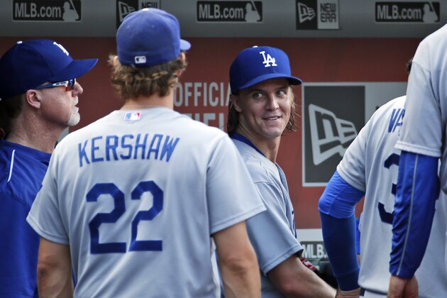 Los Angeles Dodgers starting pitcher Zack Greinke, center looks over his shoulder at Clayton Kershaw (22) after Greinke finished pitching the eighth inning of a baseball game at Nationals Park, Sunday, July 19, 2015, in Washington. The Dodgers won 5-0. (AP Photo/Alex Brandon)