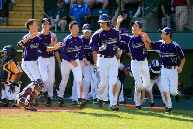SOUTH WILLIAMSPORT, PA - AUGUST 24:  Hae Chan Choi #21 of  Team Asia-Pacific celebrates with teammates after hitting a solo home run against the Great Lakes Team from Chicago, Illinois during the sixth inning of the Little League World Series Championship game at Lamade Stadium on August 24, 2014 in South Williamsport, Pennsylvania.  (Photo by Rob Carr/Getty Images)