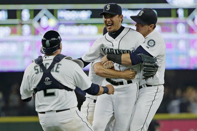 Seattle Mariners starting pitcher Hisashi Iwakuma second from right, celebrates with catcher Jesus Sucre, left, and first baseman Logan Morrison, right, after Iwakuma threw a no-hitter baseball game against the Baltimore Orioles, Wednesday, Aug. 12, 2015, in Seattle. The Mariners beat the Orioles 3-0. (AP Photo/Ted S. Warren)