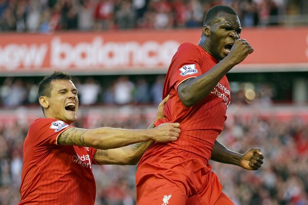 Liverpool's Christian Benteke right, celebrates with team-mate Dejan Lovren after he scores the first goal for his side during their English Premier League soccer match against Bournemouth at Anfield in Liverpool, England, Monday Aug. 17, 2015. (AP Photo/Clint Hughes)