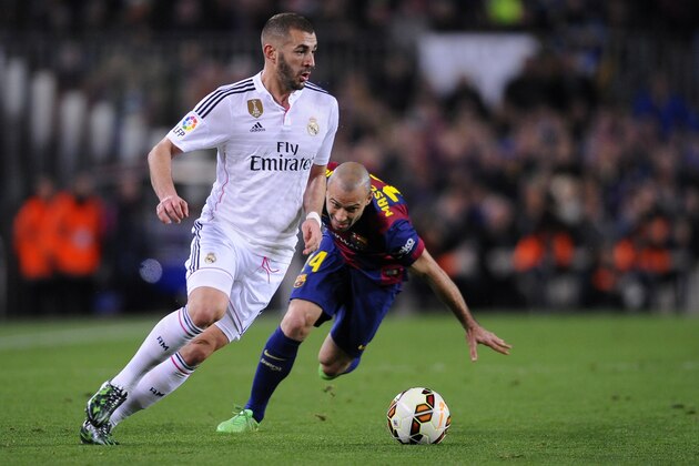 Real Madrid's Karim Benzema, left, takes the ball past Barcelona's Javier Mascherano during a Spanish La Liga soccer match between FC Barcelona and Real Madrid at Camp Nou stadium, in Barcelona, Spain, Sunday, March 22, 2015. (AP Photo/Manu Fernandez)
