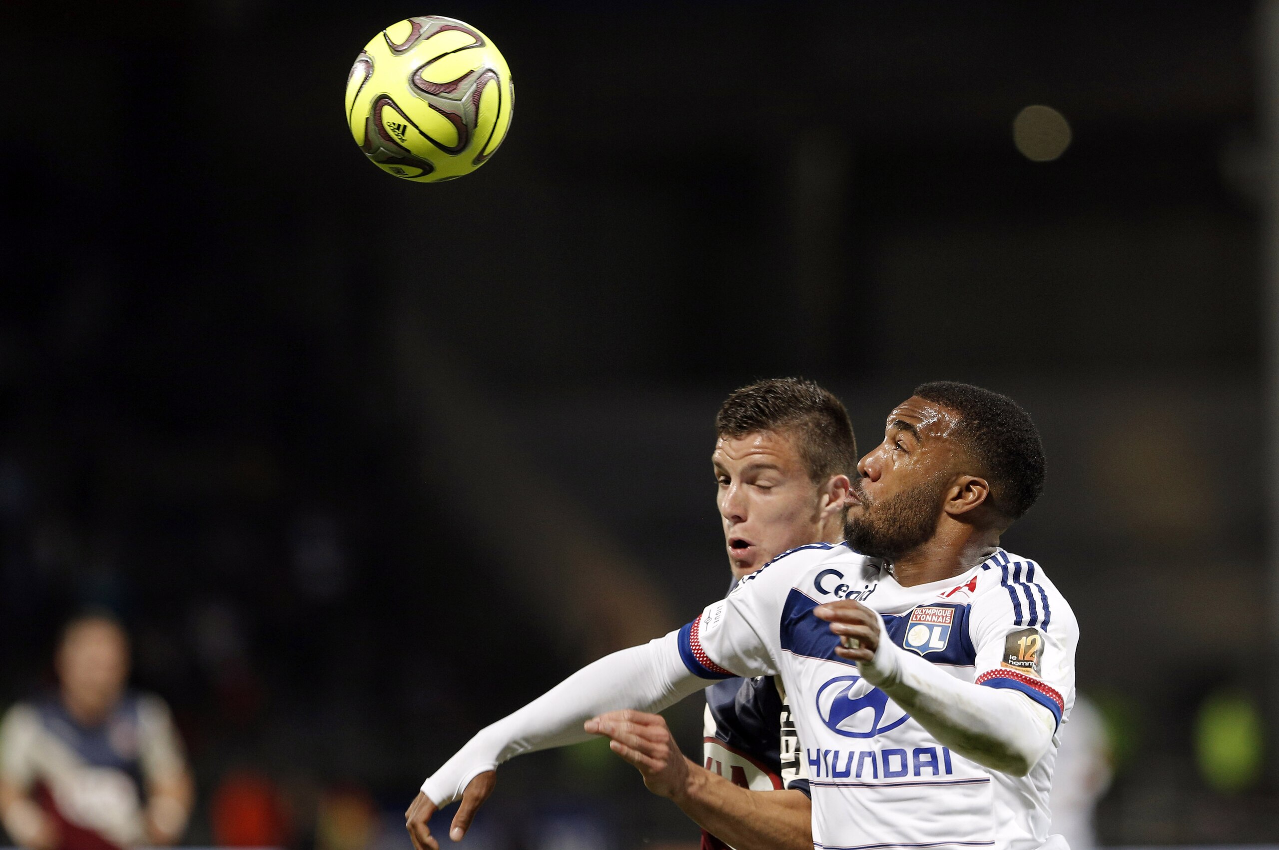Lyon's Alexandre Lacazette, right, challenges for the ball with Bordeaux' Frederic Guilbert,  during the French League One soccer match between Lyon and Bordeaux, in Lyon, central France, Saturday, May 16, 2015. (AP Photo/Laurent Cipriani)