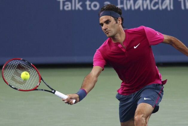 Roger Federer, of Switzerland, returns the ball to Roberto Bautista Agut, of Spain, at the Western & Southern Open tennis tournament, Tuesday, Aug. 18, 2015, in Mason, Ohio. (AP Photo/Tom Uhlman)