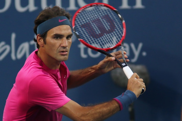 Roger Federer, of Switzerland, returns the ball to Roberto Bautista Agut, of Spain, at the Western & Southern Open tennis tournament, Tuesday,  Aug. 18, 2015, in Mason, Ohio. (AP Photo/Tom Uhlman)