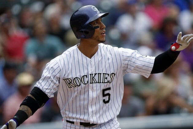 Colorado Rockies' Carlos Gonzalez follows the flight of his solo home run off San Diego Padres starting pitcher Ian Kennedy in the fourth inning of a baseball game Sunday, Aug. 16, 2015, in Denver. The Rockies won 5-0. (AP Photo/David Zalubowski)
