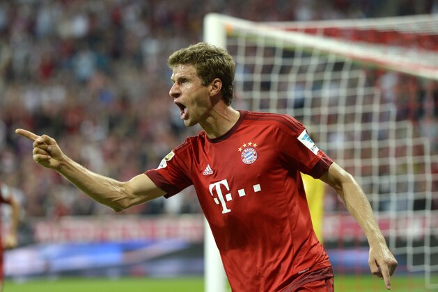 Bayern Munich's midfielder Thomas Mueller celebrates scoring the 3-0 goal during the German first division Bundesliga football match FC Bayern Munich vs Hamburger SV at the Allianz Arena in Munich, southern Germany, on August 14, 2015. The match is the first of the 2015/2016 season. AFP PHOTO / CHRISTOF STACHE

RESTRICTIONS: DURING MATCH TIME: DFL RULES TO LIMIT THE ONLINE USAGE TO 15 PICTURES PER MATCH AND FORBID IMAGE SEQUENCES TO SIMULATE VIDEO. 
== RESTRICTED TO EDITORIAL USE ==
FOR FURTHER QUERIES PLEASE CONTACT DFL DIRECTLY AT + 49 69 650050.        (Photo credit should read CHRISTOF STACHE/AFP/Getty Images)