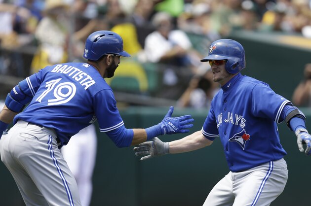 Toronto Blue Jays' Josh Donaldson, right, is congratulated by Jose Bautista (19) after hitting a home run off Oakland Athletics' Dan Otero in the fifth inning of a baseball game Thursday, July 23, 2015, in Oakland, Calif. (AP Photo/Ben Margot)
