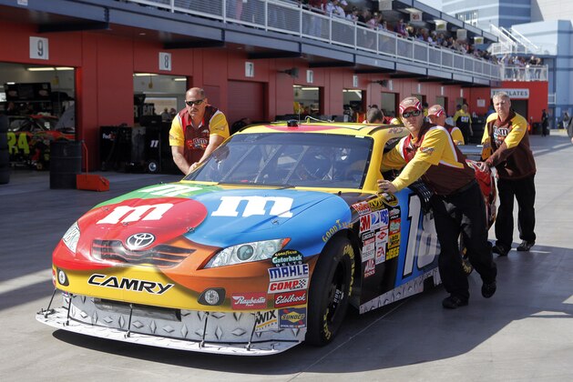 Crew members push NASCAR driver Kyle Busch's car through the garage area during practice for the NASCAR Sprint Cup series Shelby 427 at Las Vegas Motor Speedway in Las Vegas, Friday, Feb. 27, 2009.  Busch blew a motor in his car during Friday's practice session, changed the engine, then ran a pole-winning lap for the Sprint Cup series Shelby 427 auto race. But under NASCAR rules, Busch will have to drop to the back of the field at the start of Sunday's race.  (AP Photo/Jae C. Hong)